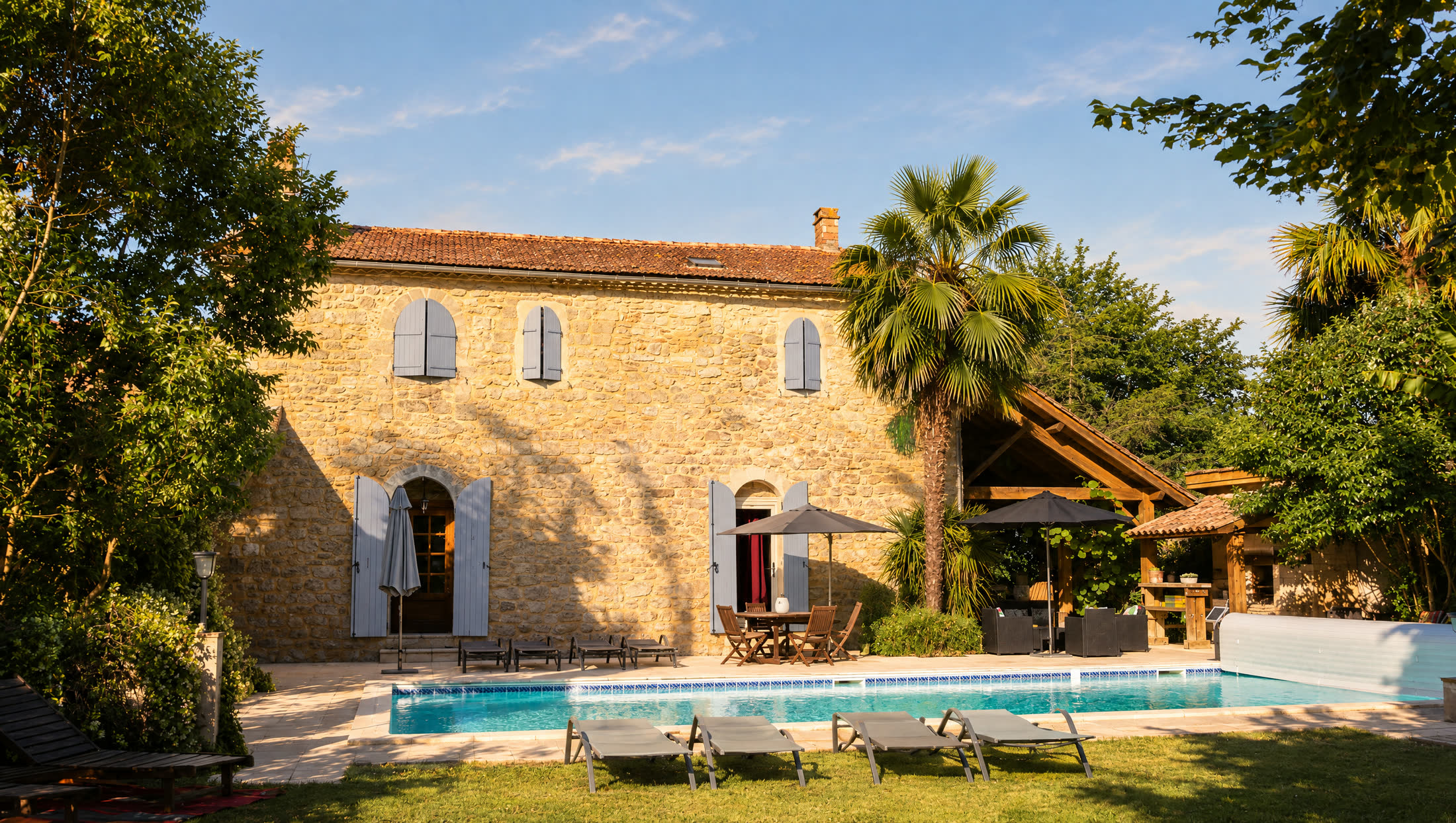 The stone house and the pool in the late afternoon