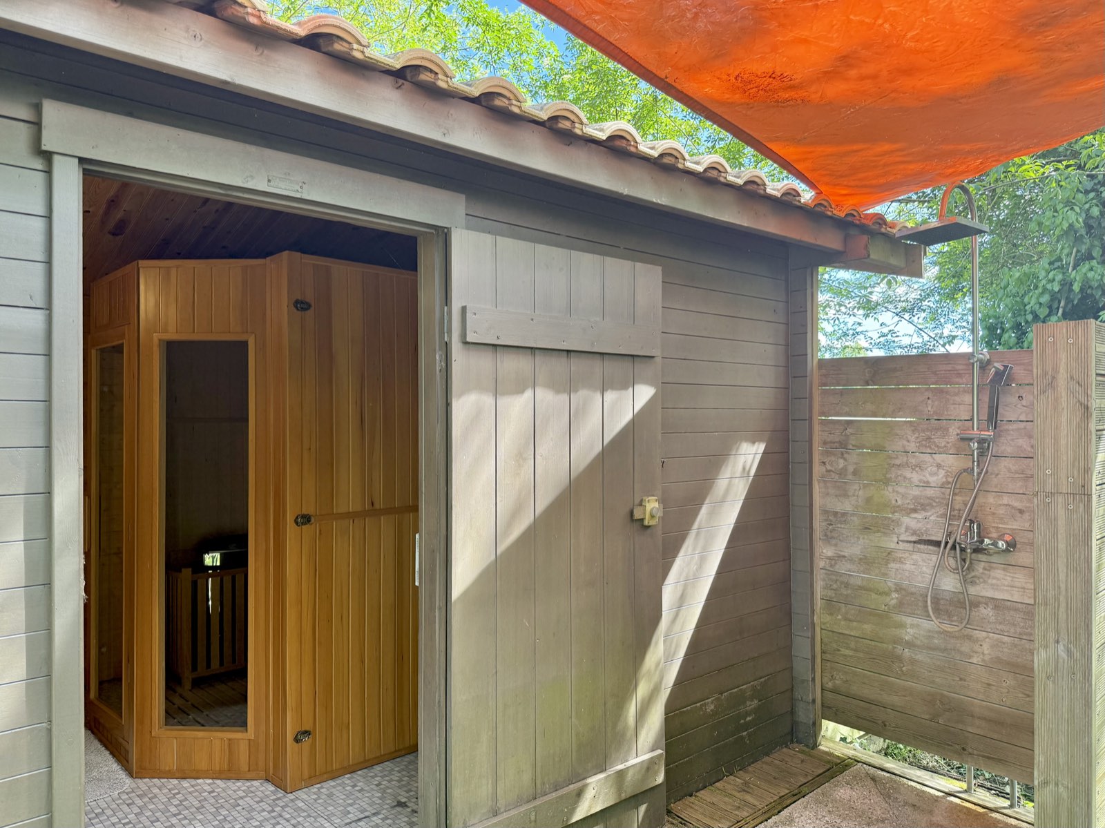 La cabine du sauna et sa douche extérieure